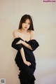 A woman in a black dress posing for a picture.