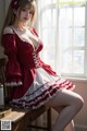 A woman in a red and white dress sitting on a chair.