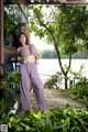 A woman in a purple and white striped outfit posing for a picture.