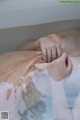 A woman laying in a bathtub with her hands on her stomach.