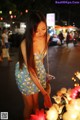 A woman in a blue dress standing next to a bunch of flowers.