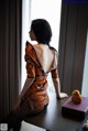 A woman sitting on a table next to a window.